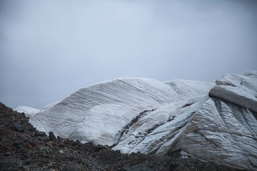 A breathtaking view of a cold, barren glacier landscape under a cloudy sky.