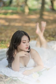 A serene woman lies on a blanket outdoors enjoying a sunny day, capturing leisure and tranquility.