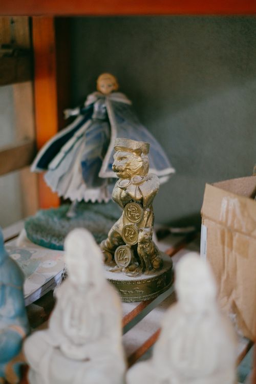Free Close-up of a golden figurine and porcelain dolls with selective focus, creating an artistic display. Stock Photo