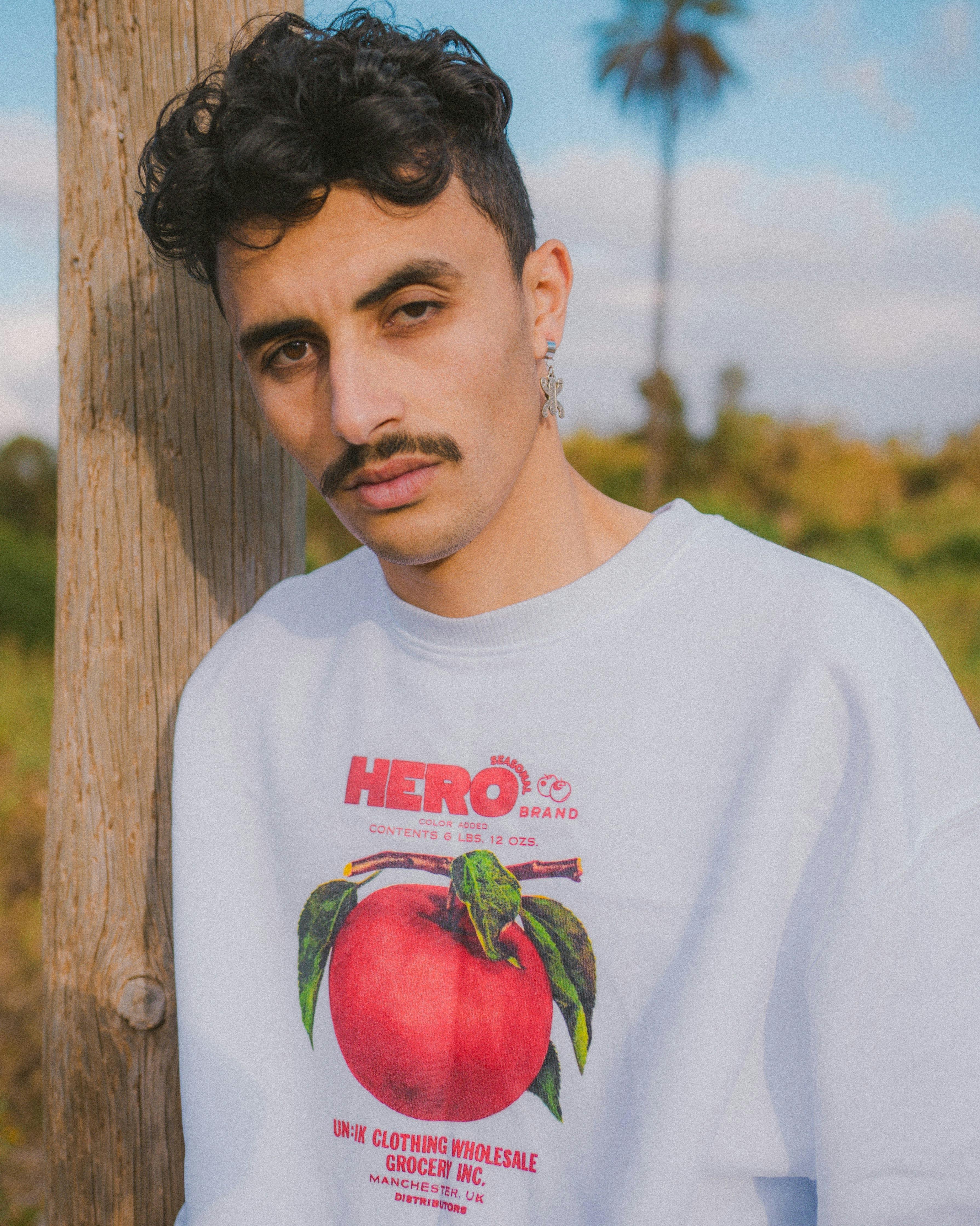 Stylish man with moustache wearing white clothes in Morocco outdoors.