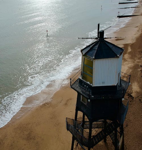 Selective Photography of Black and White Watch Tower Beside Body of Water