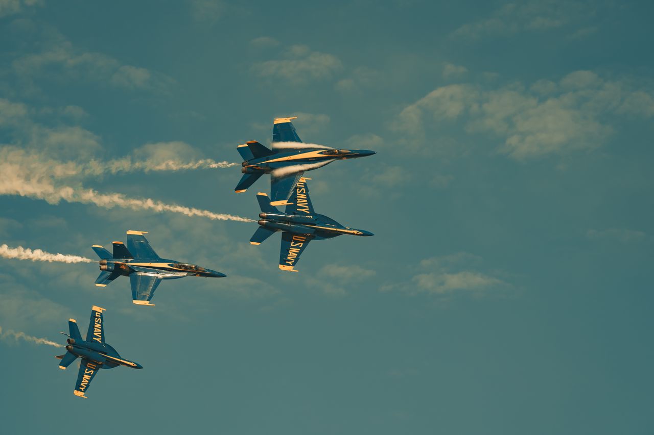 four navy jets perform a stunning aerial maneuver in a clear blue sky