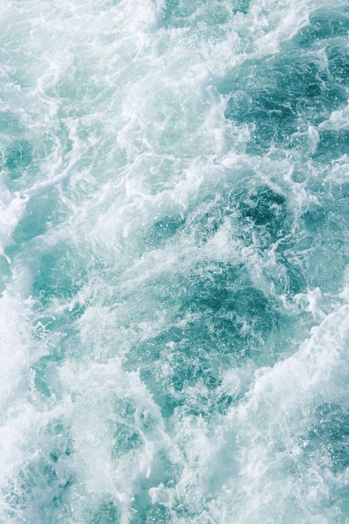 Free Captivating aerial view of turquoise ocean waves and white sea foam creating a mesmerizing pattern. Stock Photo