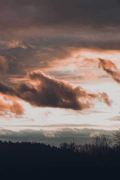 Free A captivating view of dramatic clouds at sunset, casting a silhouette over Bretten's rural landscape. Stock Photo