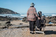 两位老妇人在岩石海滩上享受宁静时刻，拥抱友谊与平和