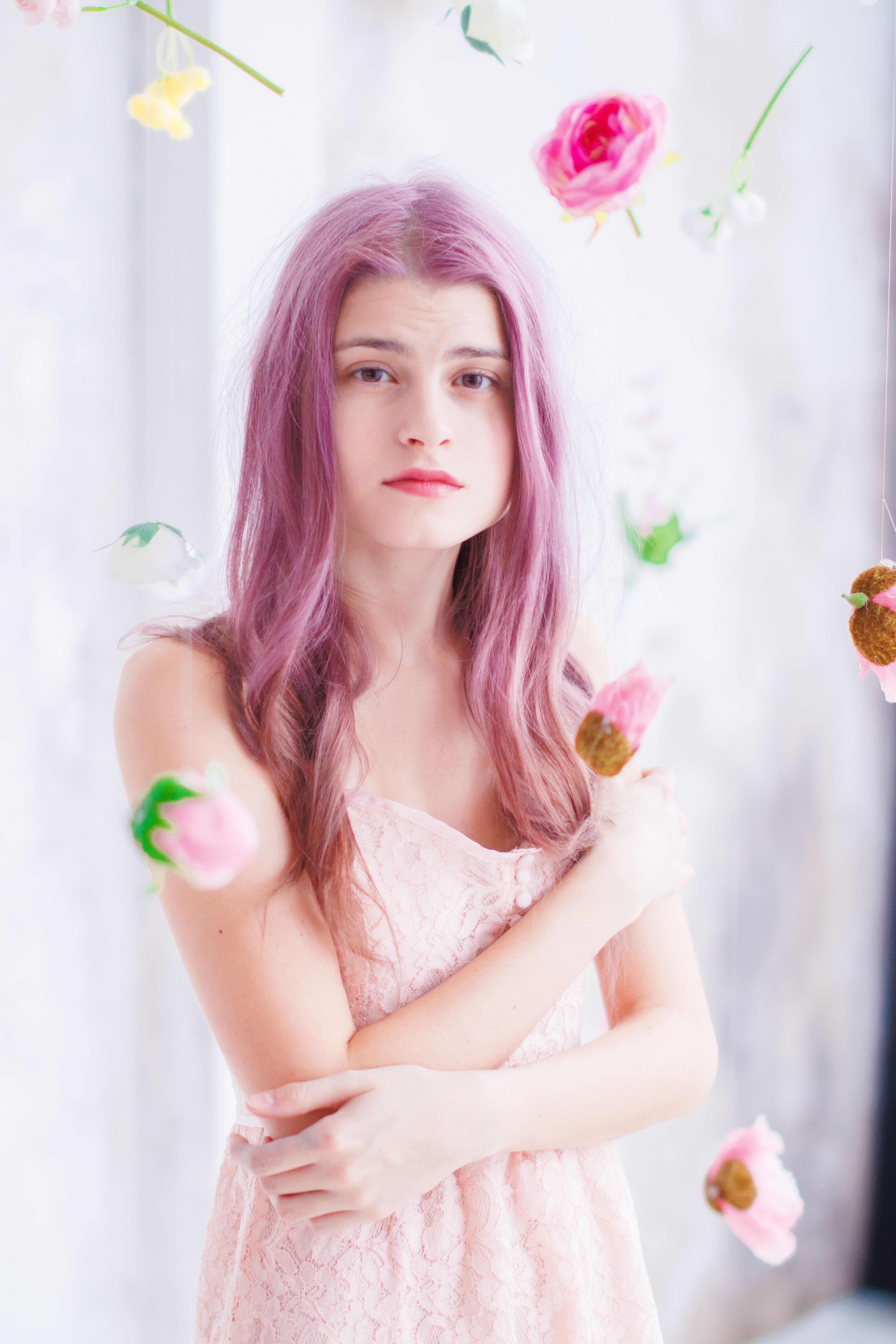 A serene portrait of a young woman with violet hair, surrounded by floating flowers.