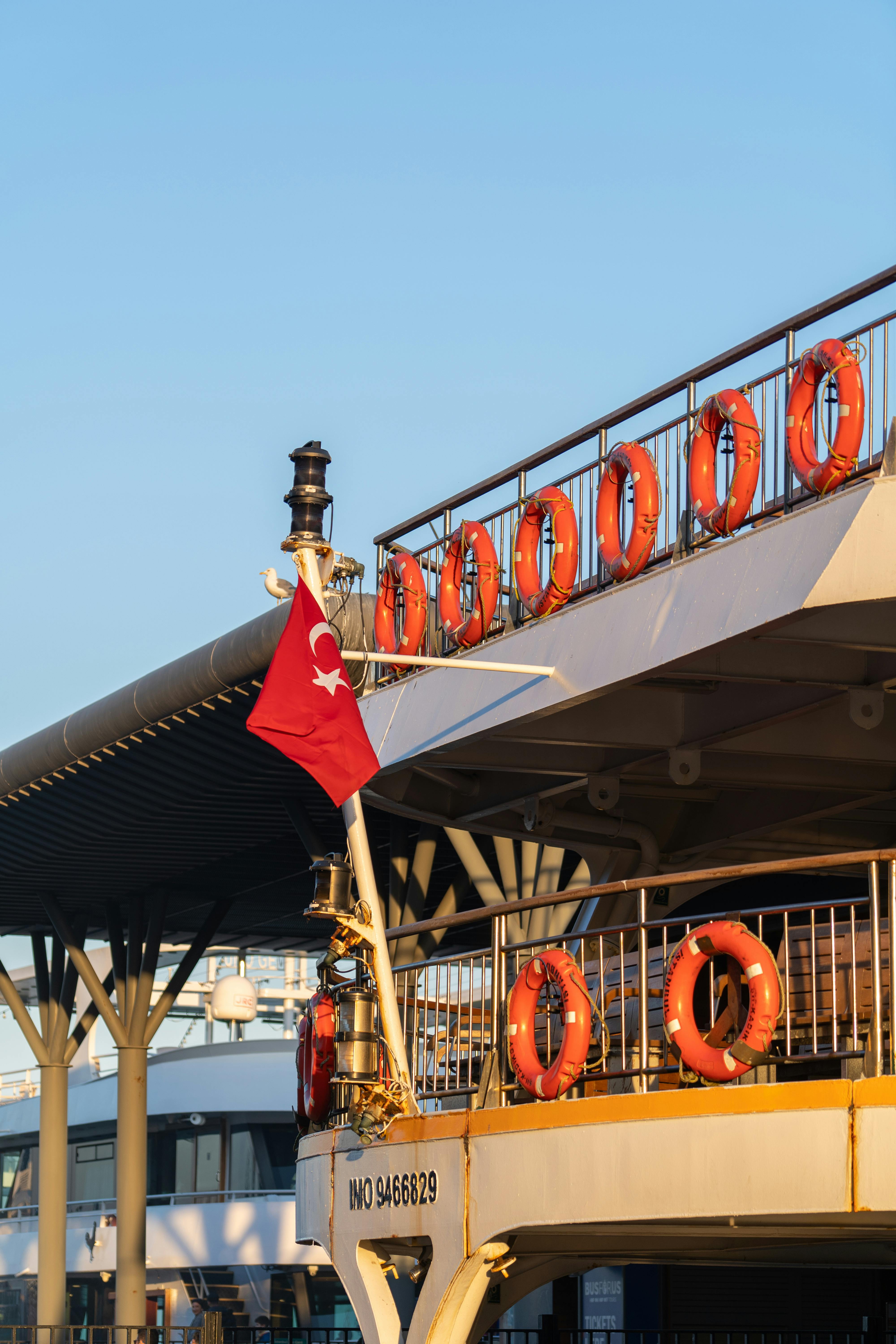 Free A ferry in Istanbul showcasing the Turkish flag and life rings at sunset. Stock Photo