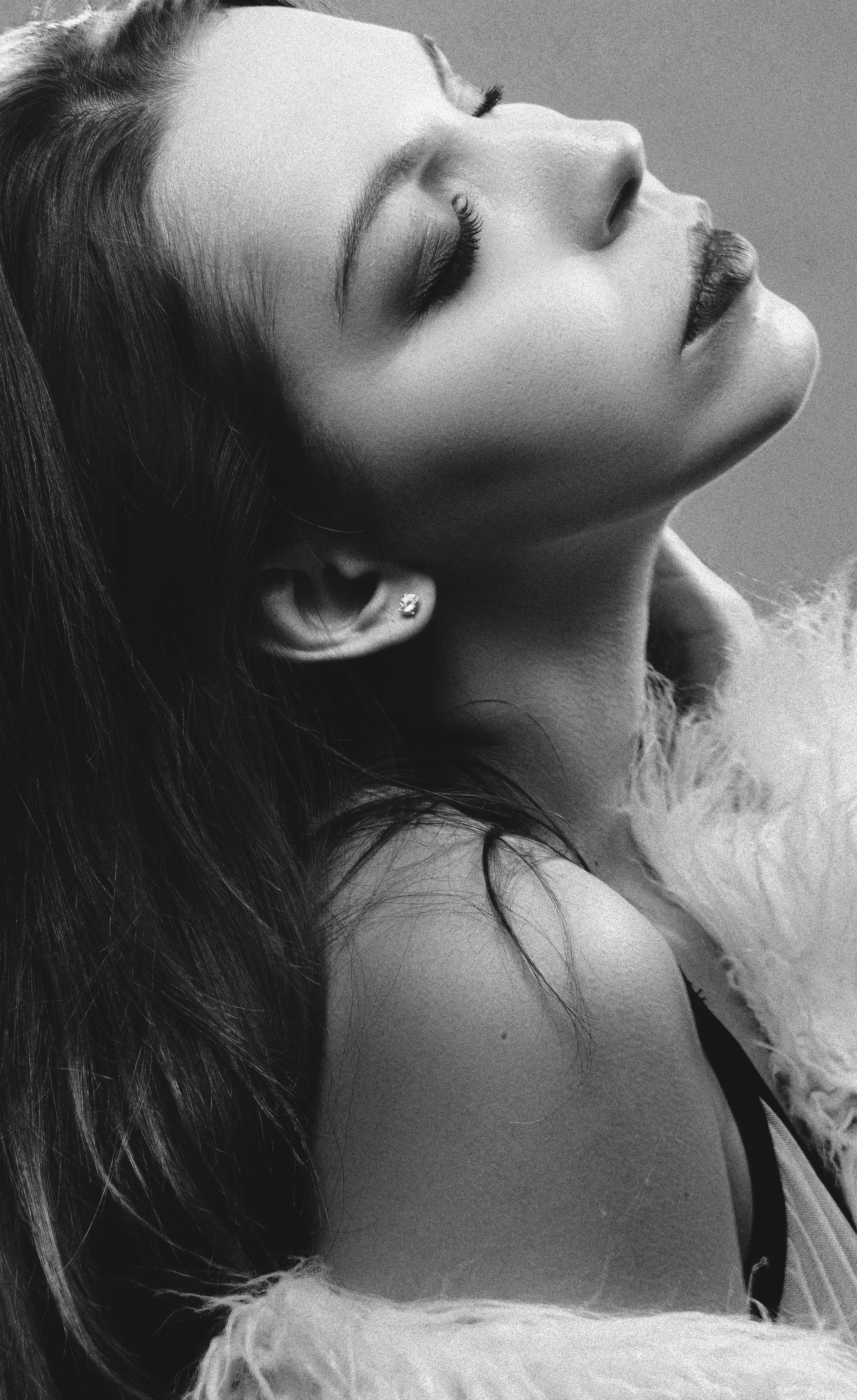 Artistic black and white portrait of a woman with eyes closed, capturing sensuality and elegance.