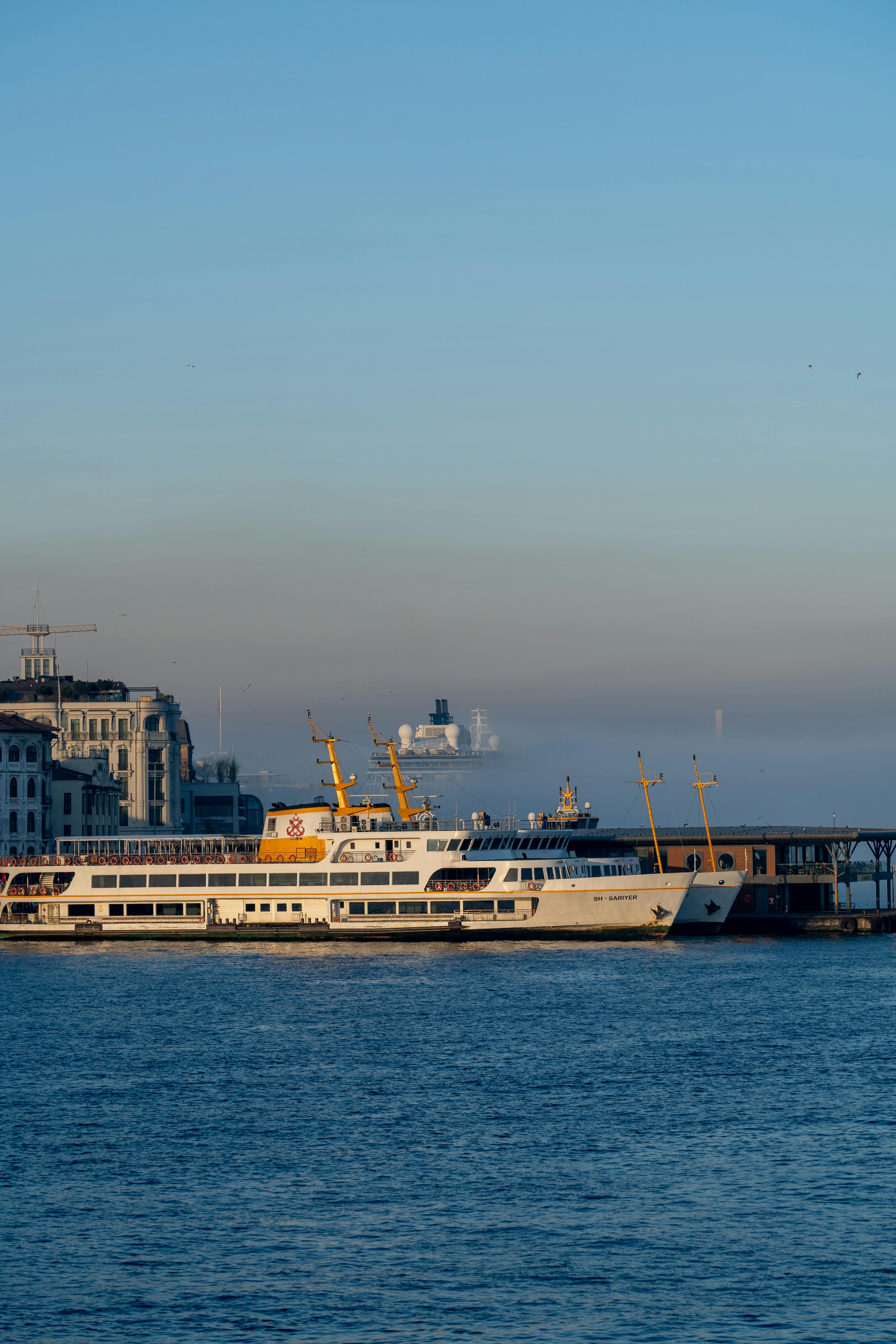 Free A scenic view of a ferry docked at a bustling harbor in a cityscape setting. Stock Photo