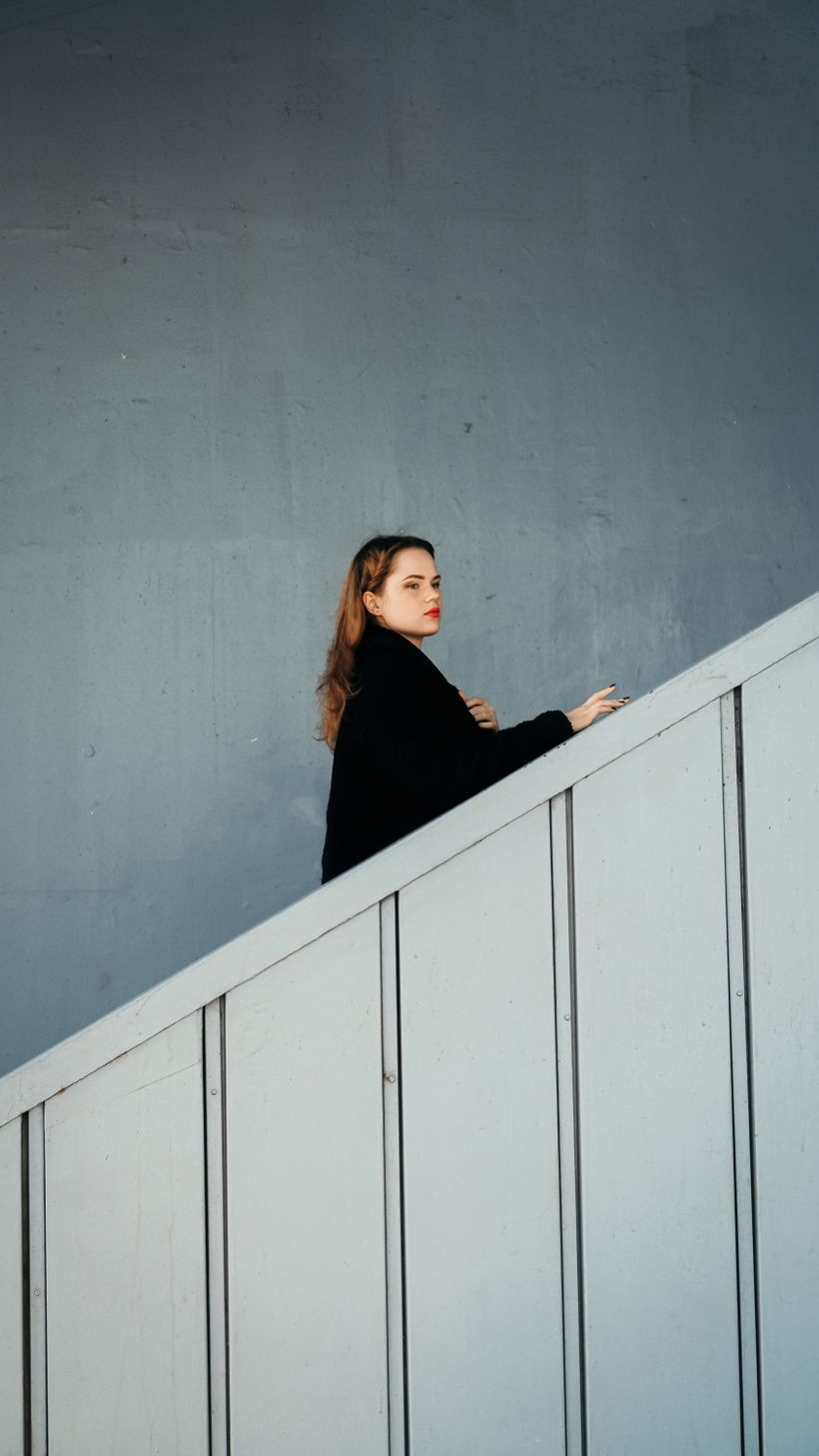 Model in a bone-white oversized anorak against concrete — photo by Dilara Kılınç on Pexels