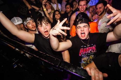 Free Excited young adults enjoying a vibrant party atmosphere at a music event. Stock Photo