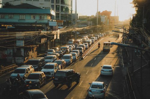 Free A bustling city street with heavy traffic, cars lining the road as the sun sets. Stock Photo