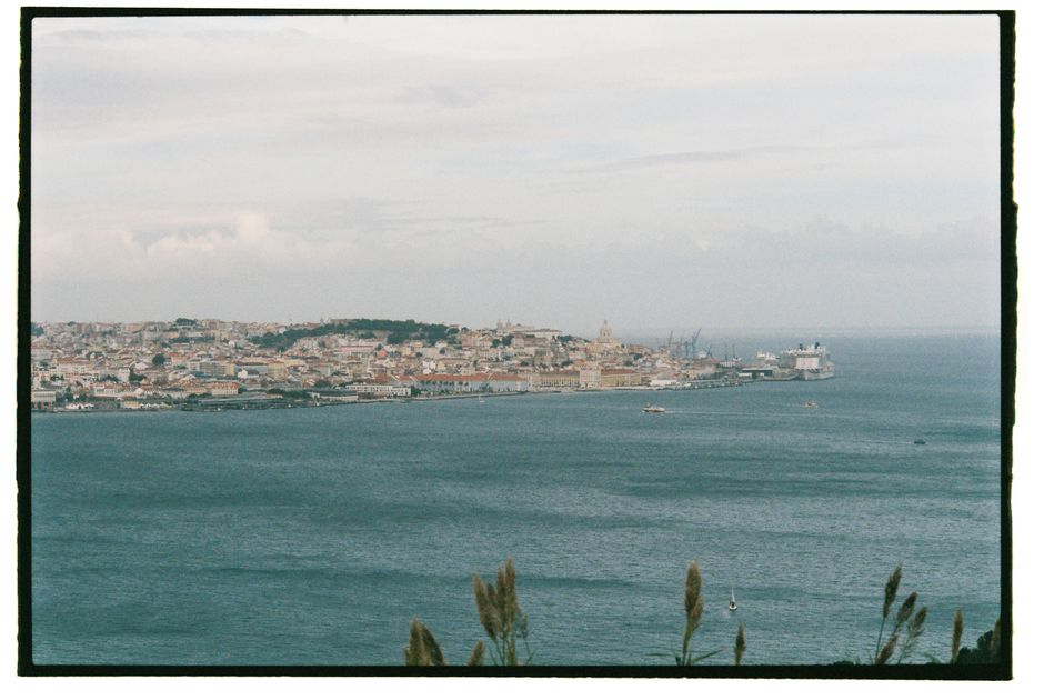 A picturesque view of Lisbon's coastline, capturing historic architecture and the vast sea.