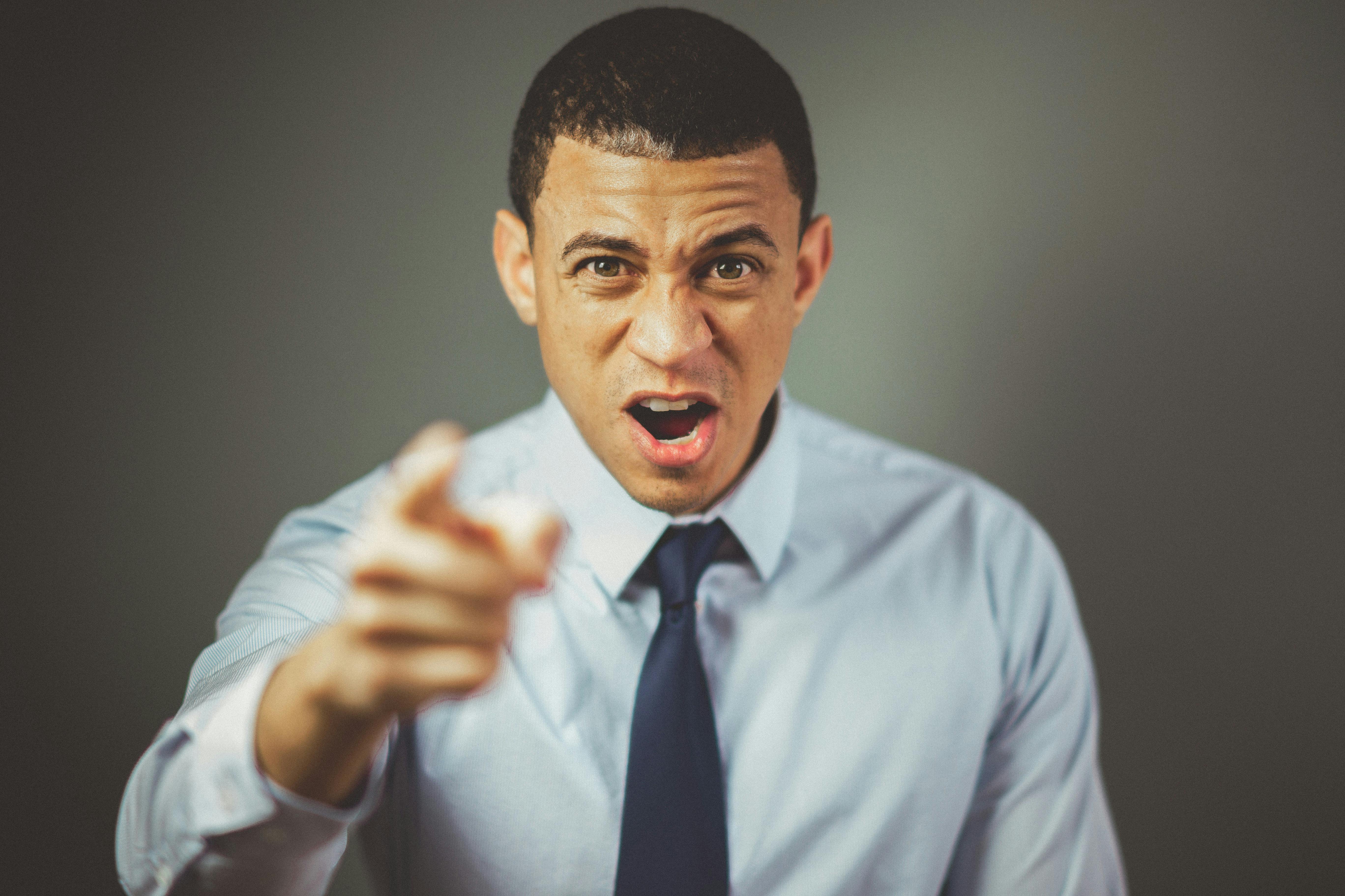 Angry man wearing white dress shirt with black necktie. | Photo: Pexels