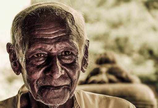 Close-up portrait of a thoughtful elderly man with expressive eyes and weathered skin.