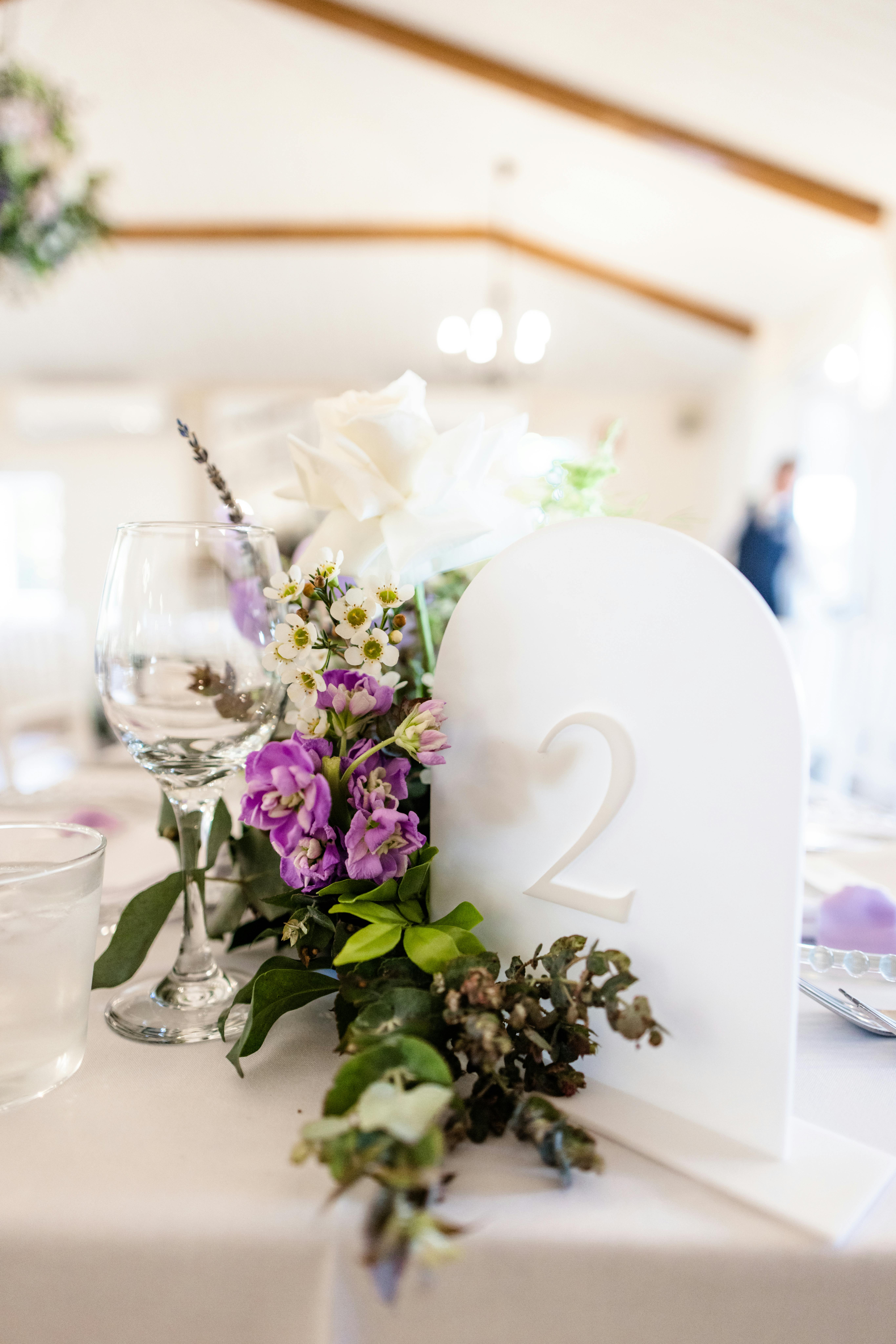 Elegant wedding place cards on a table next to a floral centerpiece