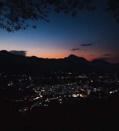 City lights below a mountain ridge at dusk, photo by Allan Carvalho on Pexels