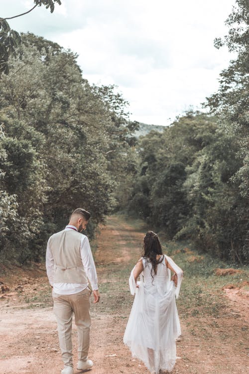 Newlywed Couple Walking Together down a Country Road 