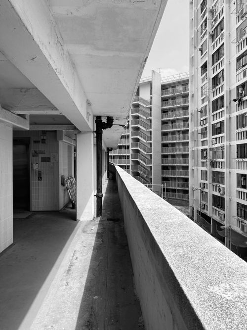 Free Black and white photo of apartment buildings with a concrete corridor view. Stock Photo