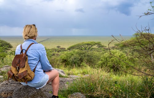 Woman Sitting with Trees and Plains behind