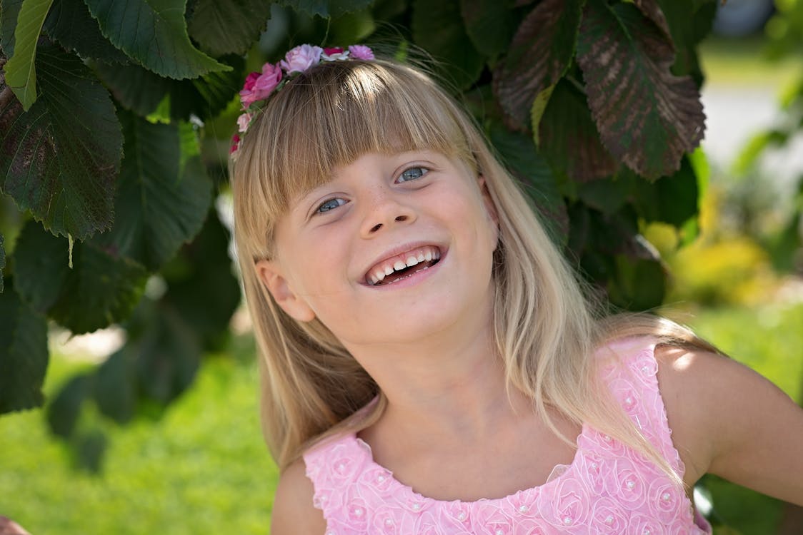 Kostenlos Mädchen, Das Rosa Blumentankerkleid Lächelnd Trägt Stock-Foto