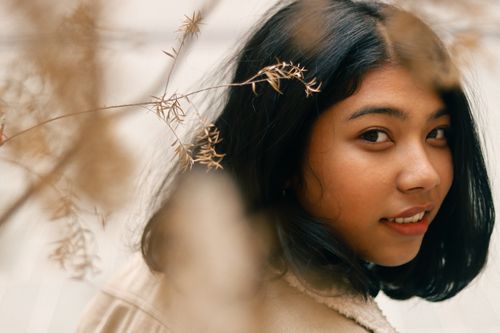 Free Portrait of a smiling young woman with natural elements in Kathmandu, Nepal. Stock Photo