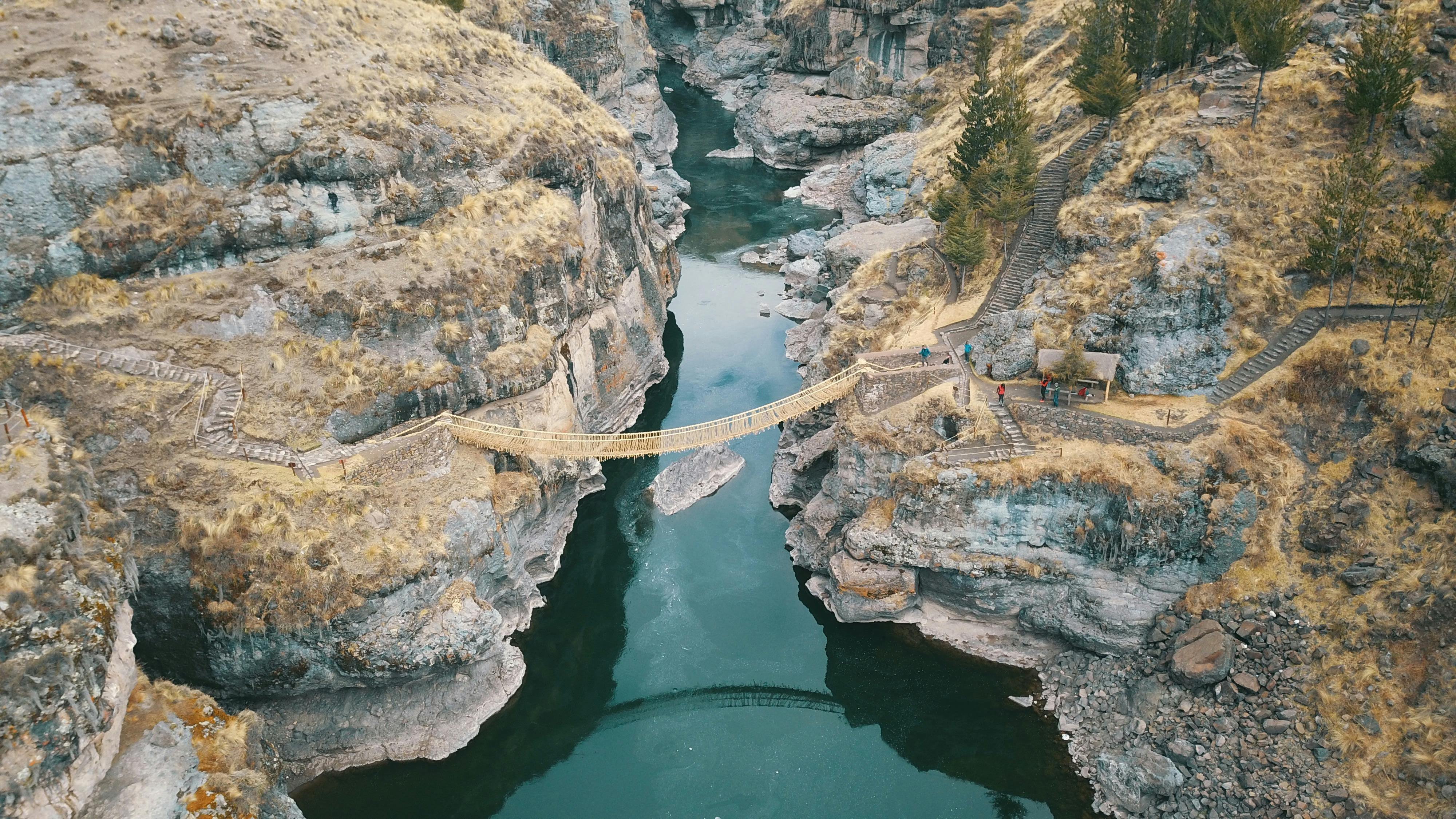 aerial photography of brown hanging bridge connecting two cliffs