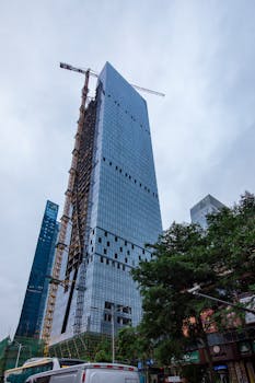 在繁华的市区，起重机正在建设现代摩天大楼