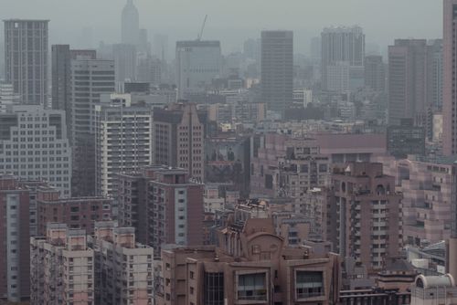 Free Aerial view of a densely packed urban skyline with hazy skyscrapers and smoggy atmosphere. Stock Photo