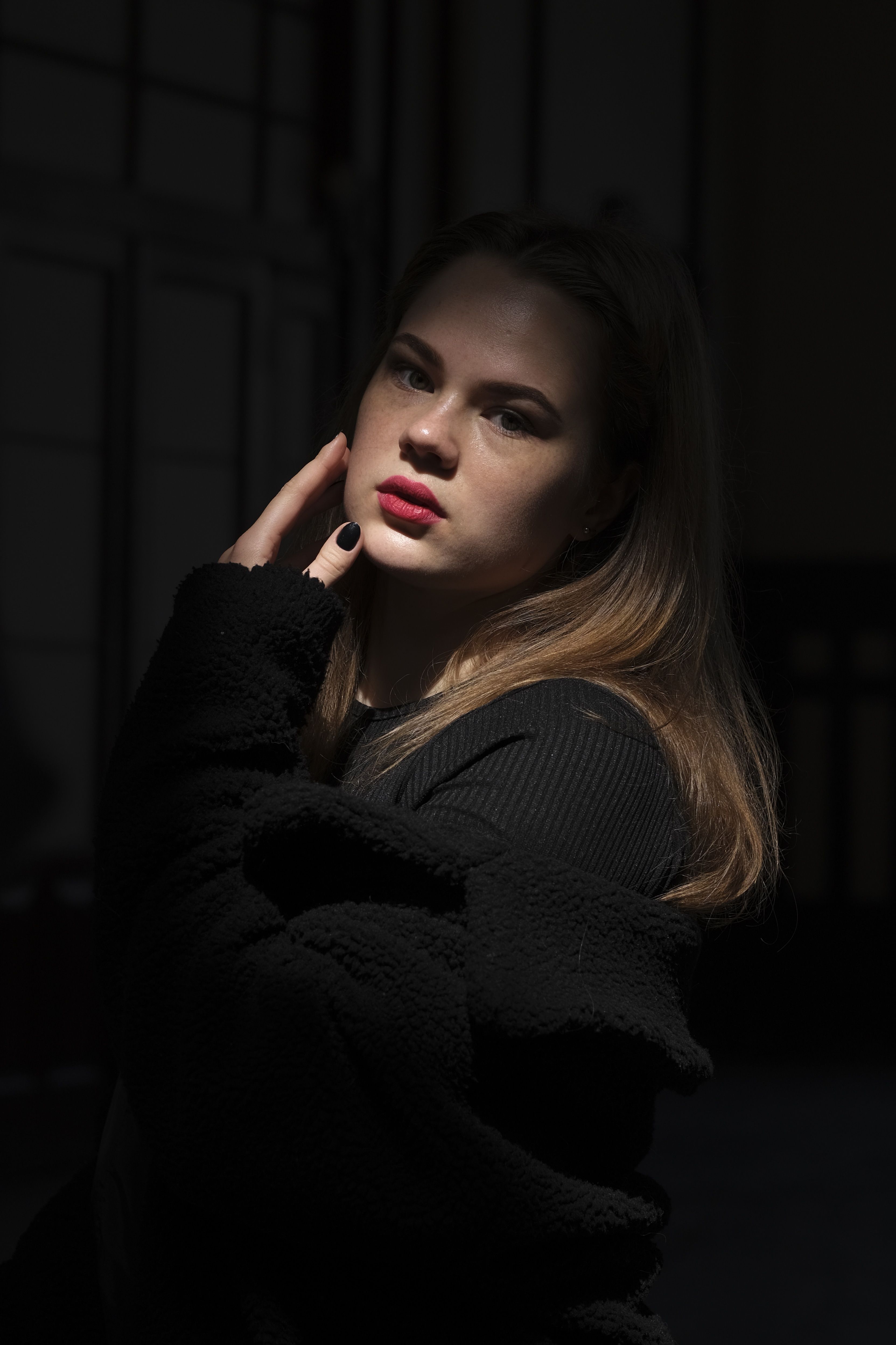 Young Woman in a Black Outfit Posing in a Dark Room · Free Stock Photo
