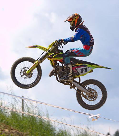 Free Rider performing an airborne trick on a motocross bike, showcasing speed and agility. Stock Photo