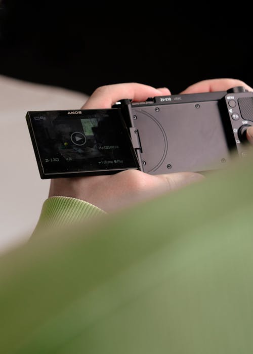 Close-up of a Person Holding a Camera and Looking at the Footage in the Viewfinder 