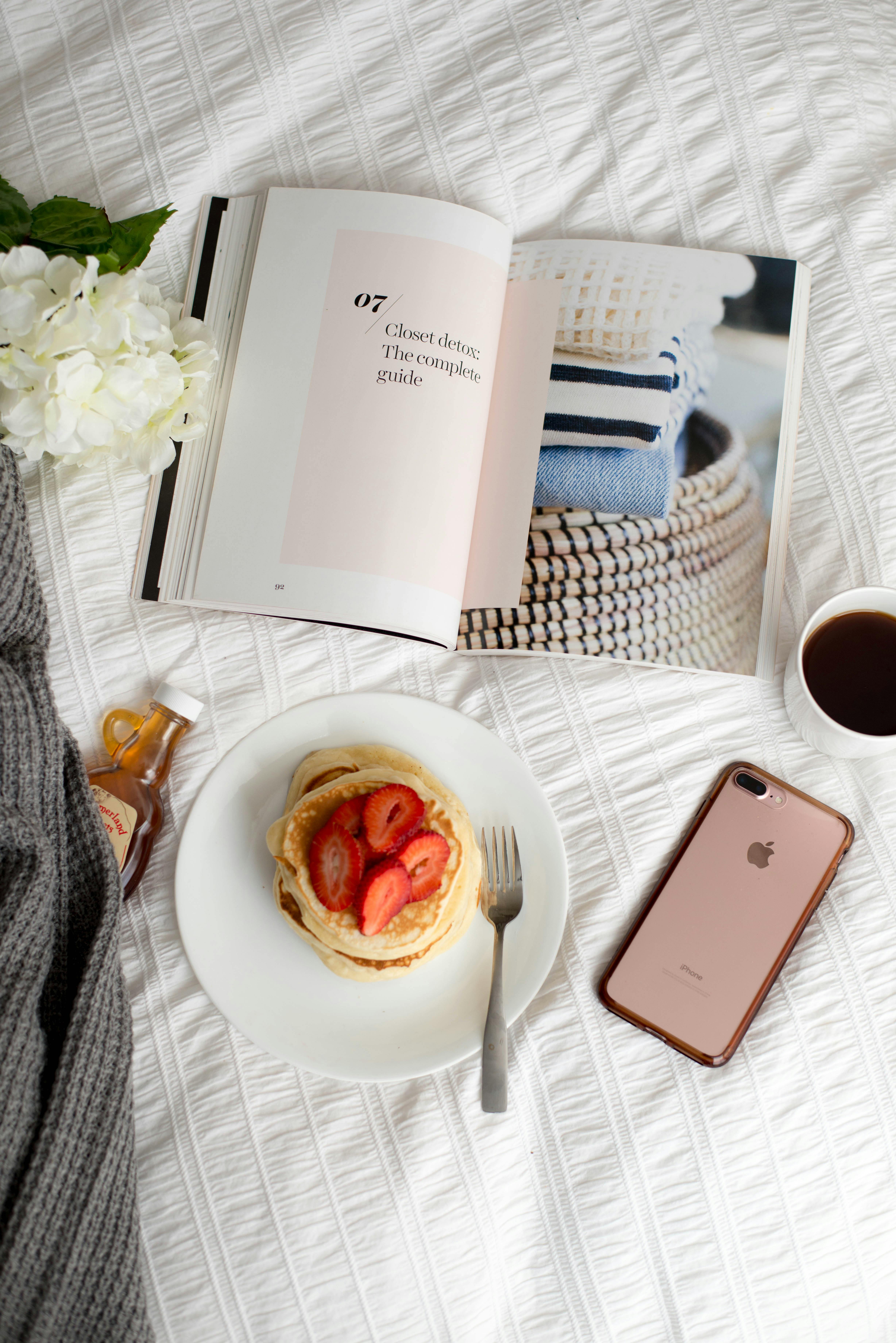Morning scene with pancakes, coffee, and a book on a white background.