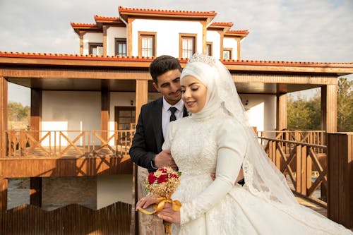 Portrait of Newlyweds near House