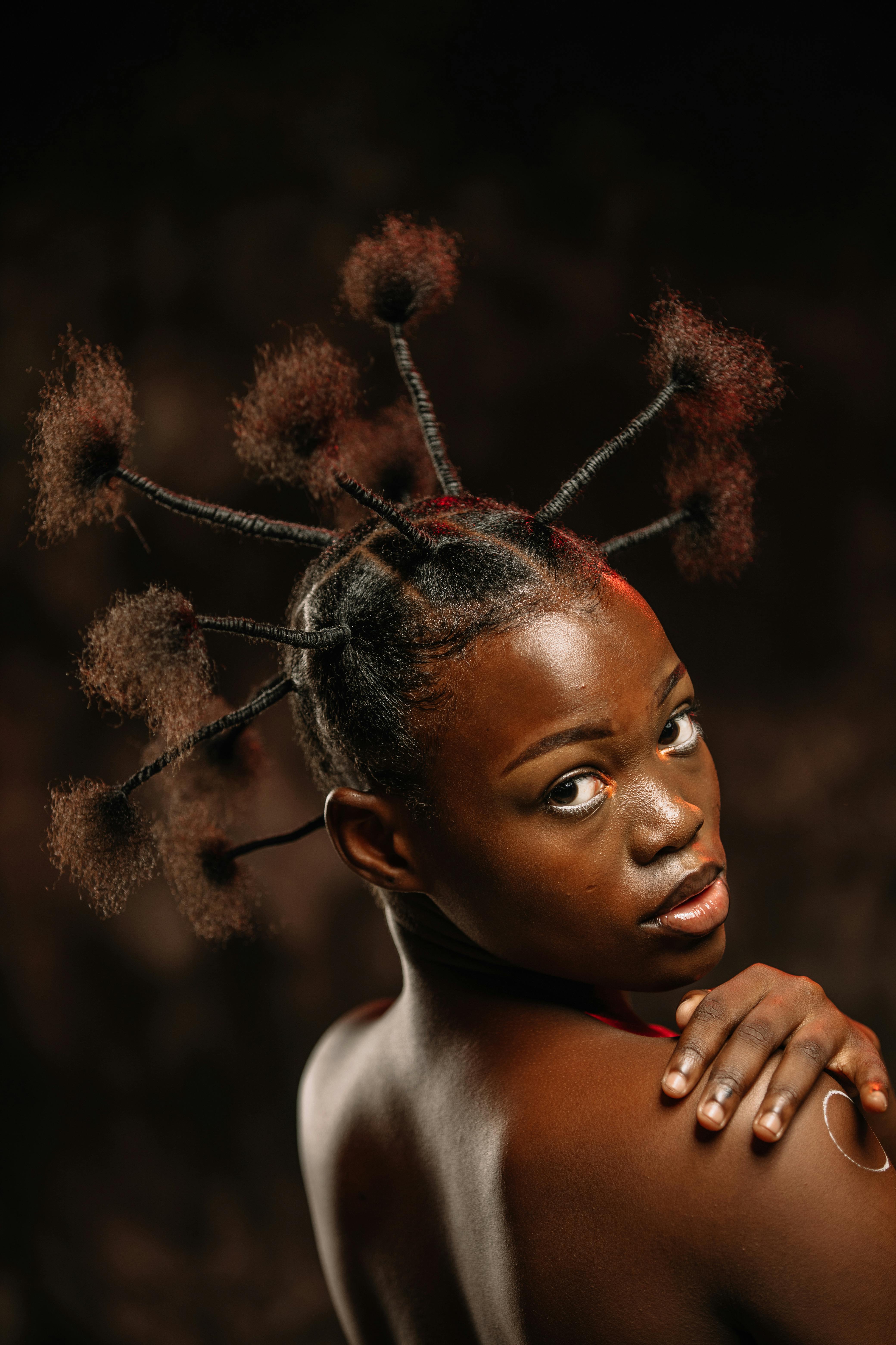Captivating fashion portrait of an African woman with a creative hairstyle, showcasing cultural beauty.