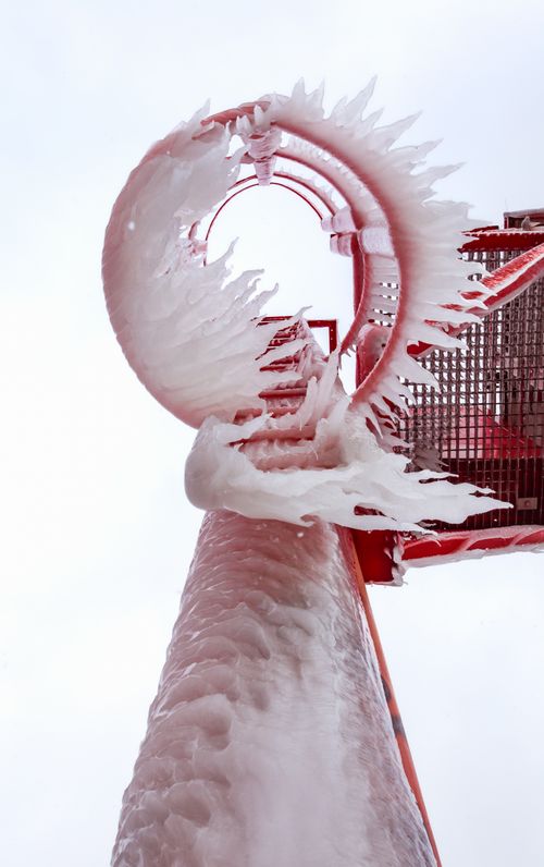 Free Close-up of an ice-covered red lighthouse ladder during winter season. Stock Photo
