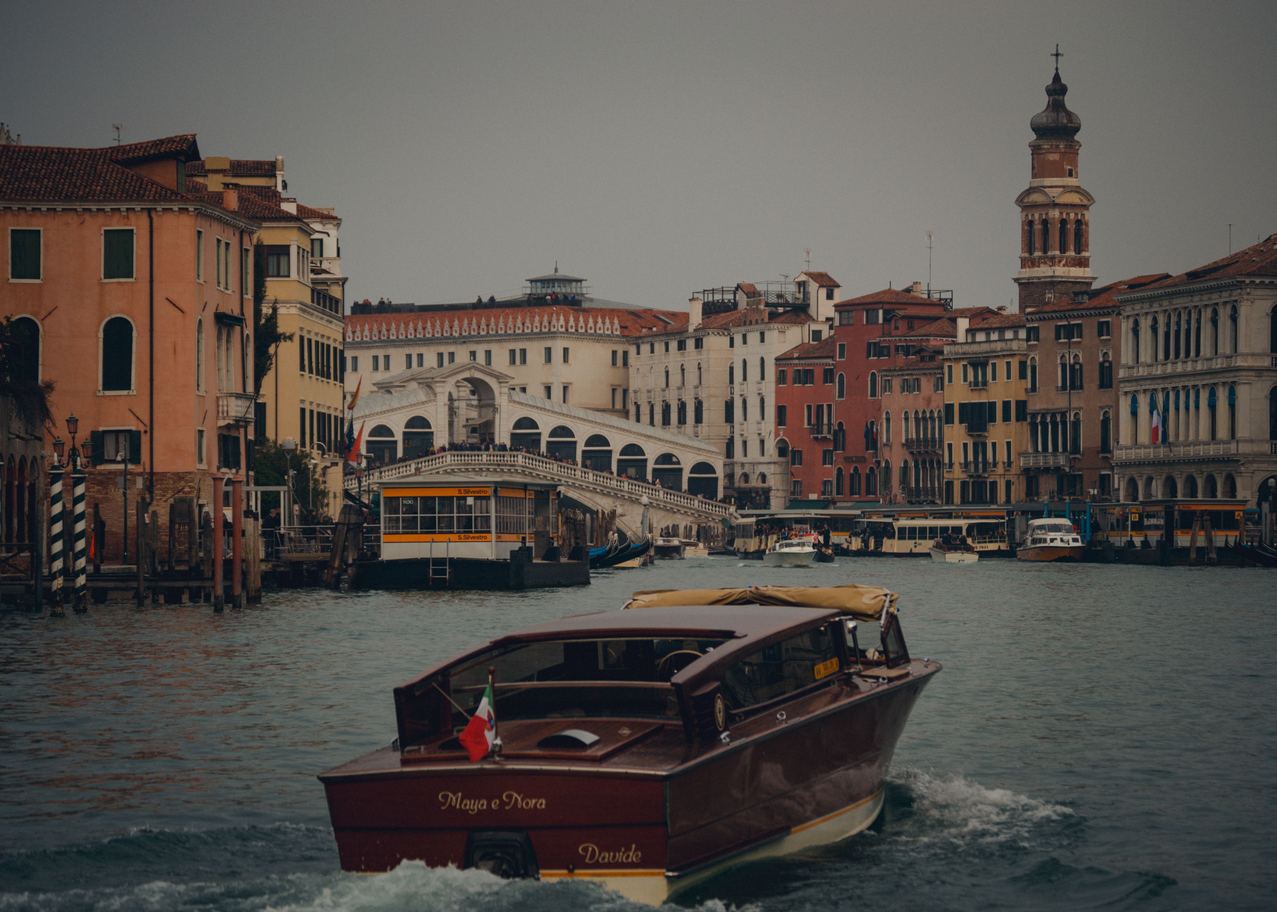 Explore the iconic Rialto Bridge and Grand Canal in Venice, Italy, featuring vibrant architecture and a charming boat.