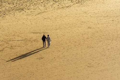 Woman and Man Walking on Desert