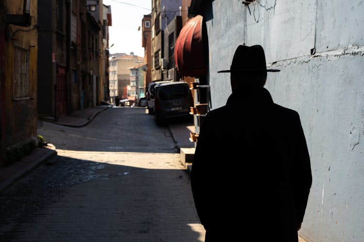 Silhouette Of Man Wearing Hat In City