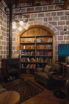 Warm and inviting cozy corner with a bookshelf and armchair in a rustic interior.