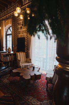 A cozy and luxurious living room featuring vintage armchairs, a rustic table, and warm lighting.