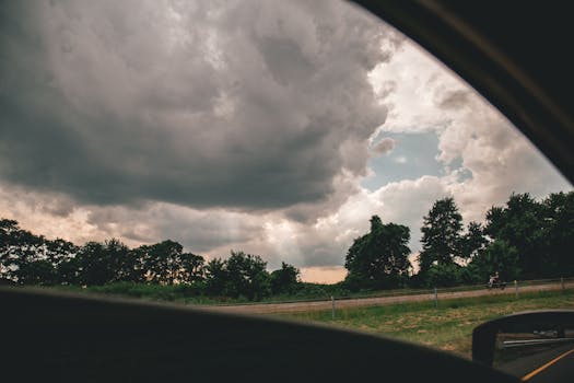 从车窗望去，戏剧性的多云天空与乡村景观交相辉映