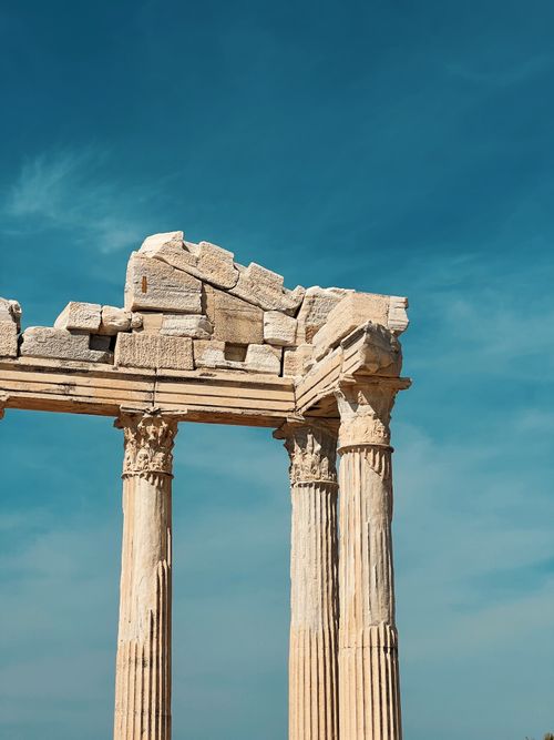 Free Vertical shot of the ancient Apollon temple ruins with classical marble columns against a clear blue sky in Side, Turkey. Stock Photo