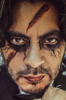 Close-up portrait of a man with elaborate face paint and makeup, perfect for Halloween or theatrical scenes.