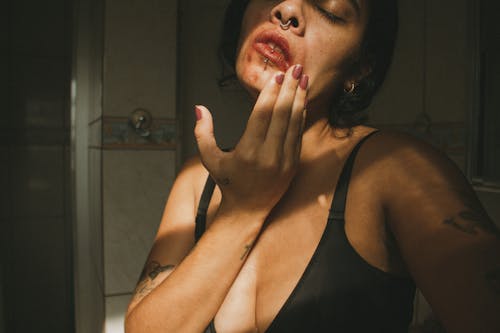 Young Shirtless Woman Smearing Lipstick over her Face
