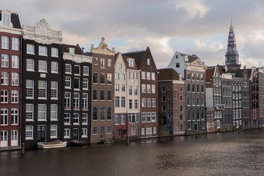Charming view of iconic canal houses along Damrak in Amsterdam, Netherlands.