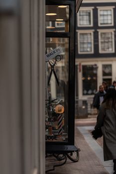 Barber shop with a walk-in sign on a bustling city street. Scissors logo visible.