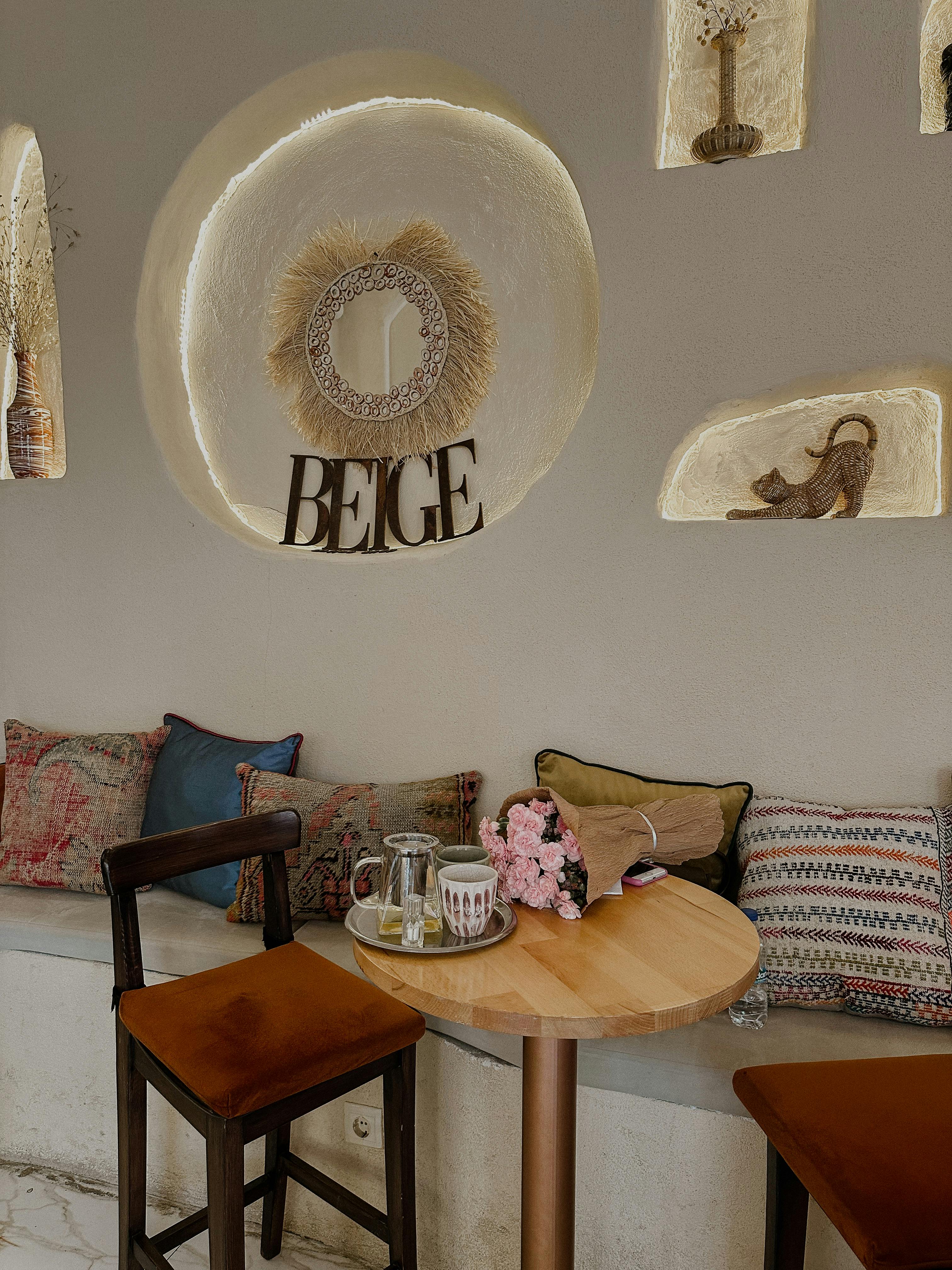 Warm and inviting cafe corner with wooden table and chairs, decorated in a beige theme.
