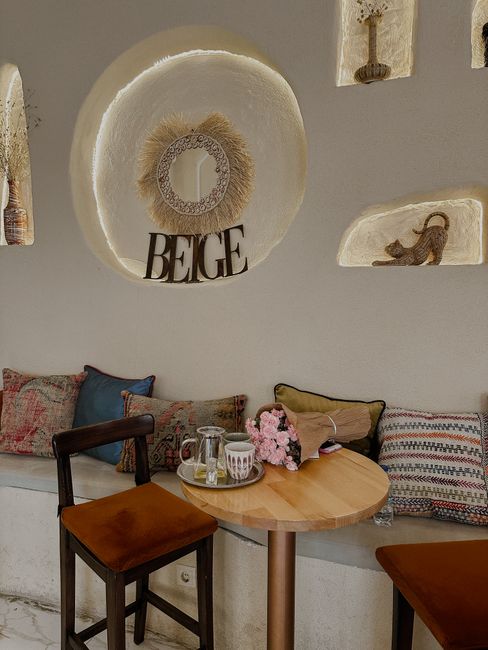 Warm and inviting cafe corner with wooden table and chairs, decorated in a beige theme.