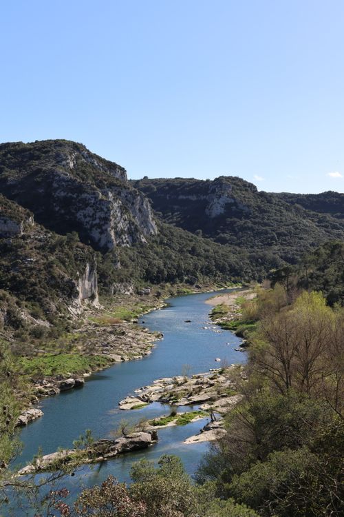 Free Scenic view of a tranquil river and cliffs in Collias, Occitanie, France. Stock Photo
